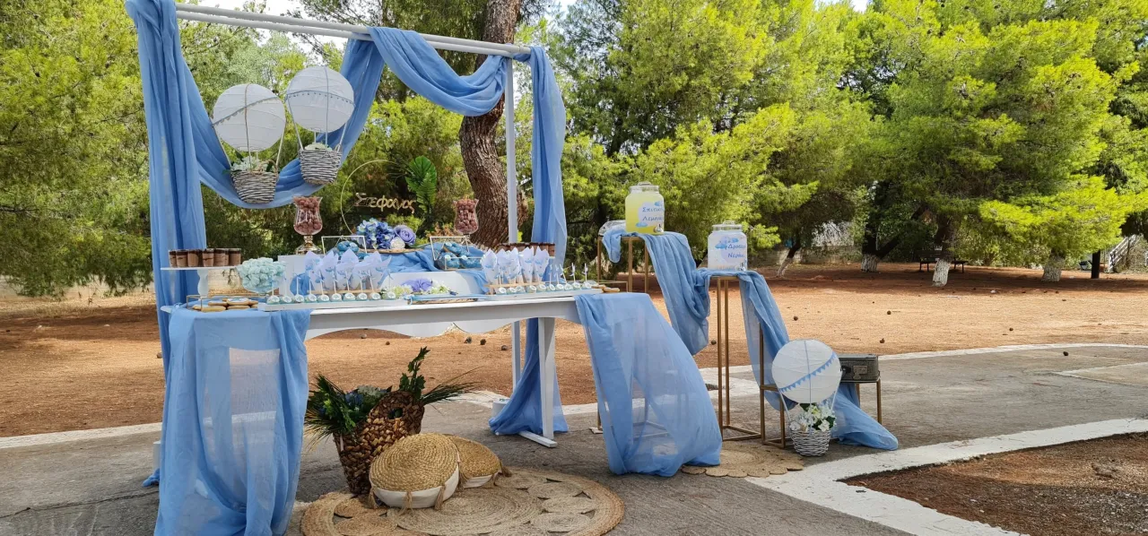 Candy bar με γαλάζια υφάσματα δίπλα στη θάλασσα.